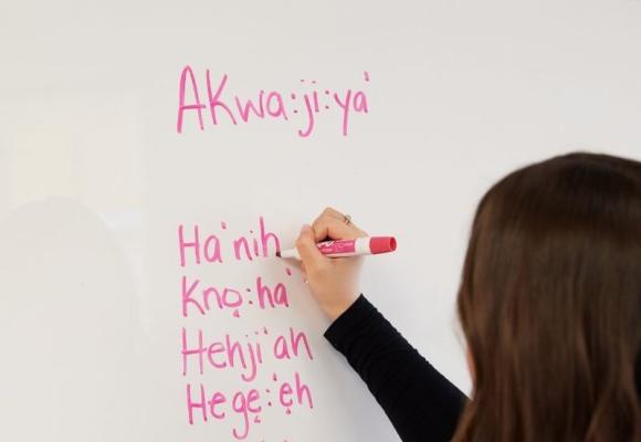 woman writing languages on board