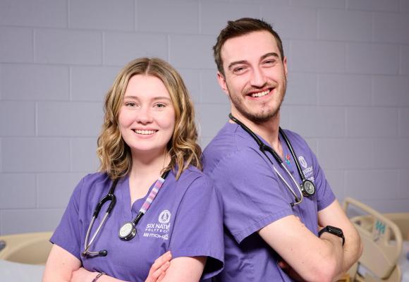 two nursing students back to back