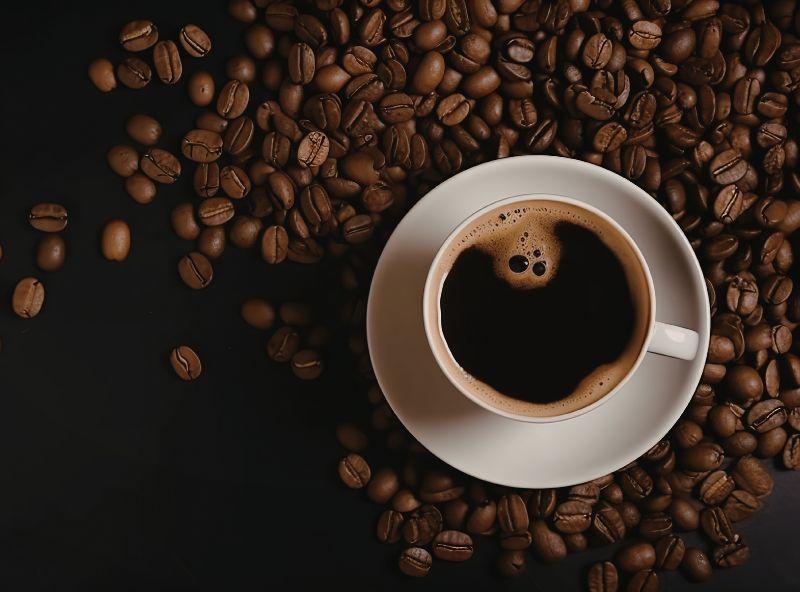 cup of coffee surrounded by coffee beans