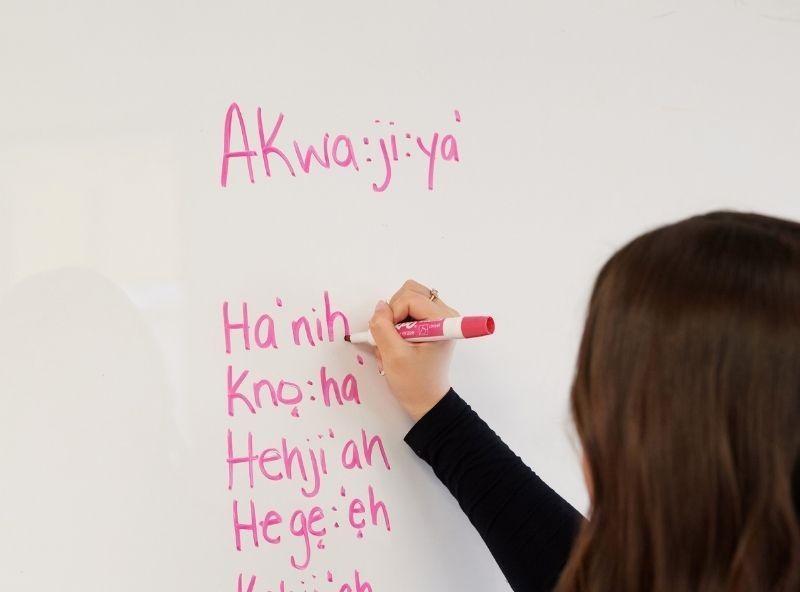 woman writing languages on board