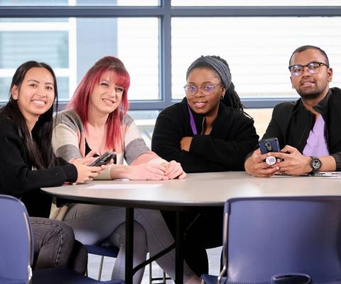 students sitting at table smiling
